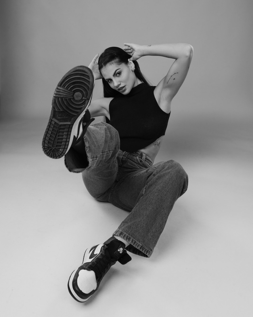 Mulher sentada no chão com tênis, preto e branco