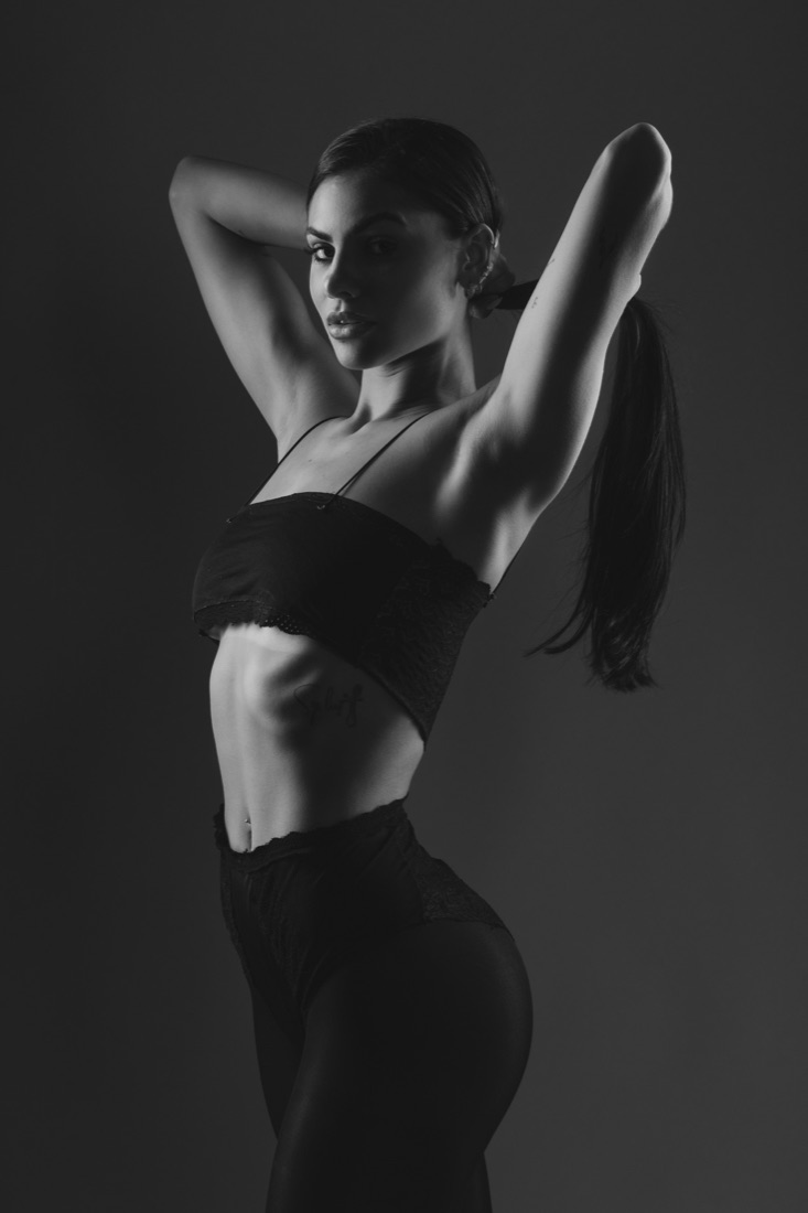 Retrato de mulher em preto e branco com os braços erguidos